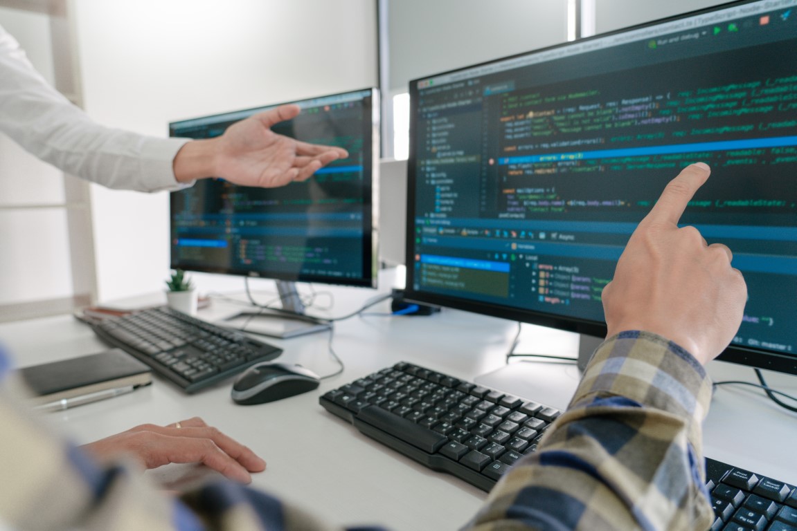 Pensive programmer working on desktop pc programming code techno Site Maintenance